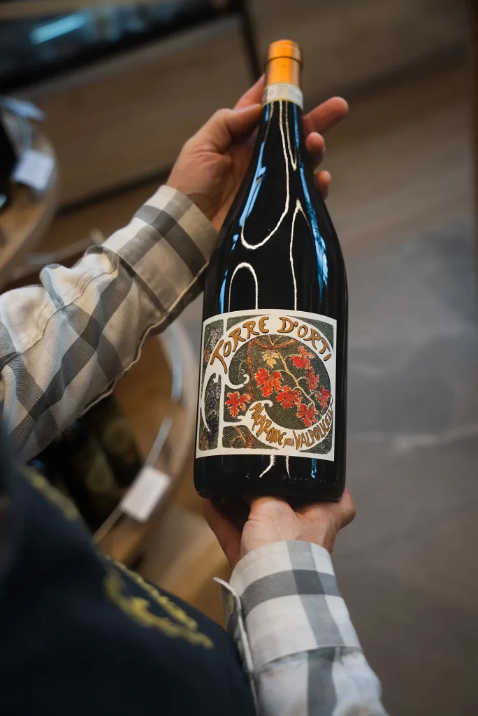 Hand holding a bottle of Torre d’Orti wine